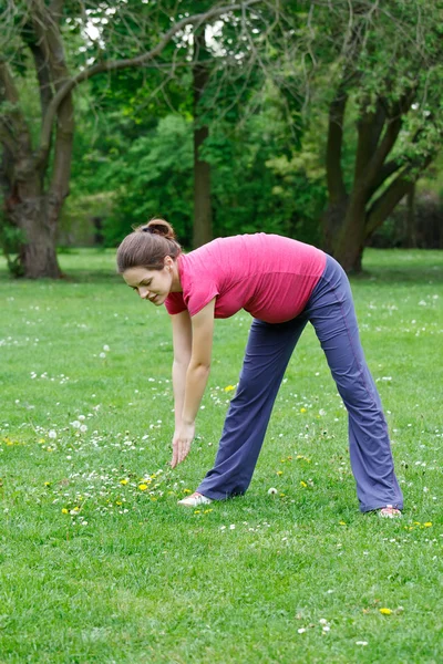 Mujer embarazada haciendo ejercicio en el parque —  Fotos de Stock
