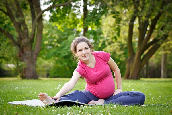 Беременная женщина, занимающаяся в парке — стоковое фото