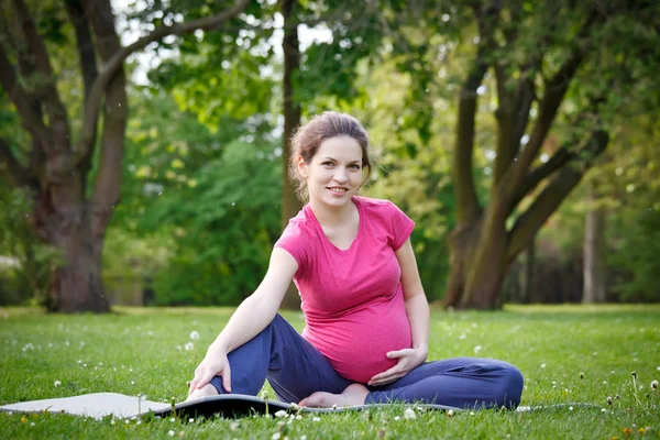 Беременная женщина, занимающаяся в парке — стоковое фото