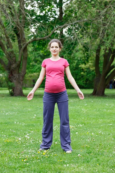 Pregnant woman exercising in the park — Stock Photo, Image