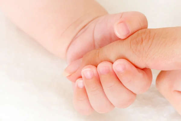 Közelkép a baba kezéről, ahogy az anya ujját fogja. — Stock Fotó