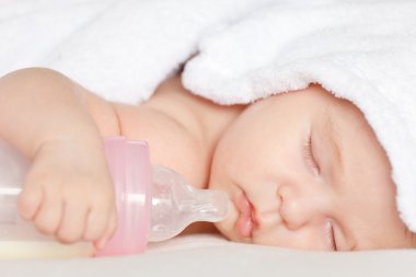 Sleeping baby with bottle clipart