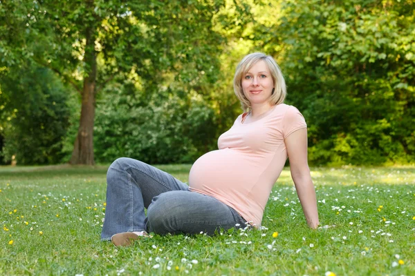 Mulher grávida descansando no parque — Fotografia de Stock
