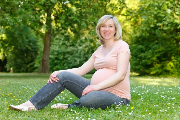 Έγκυος γυναίκα αναπαύεται στο πάρκο — Φωτογραφία Αρχείου