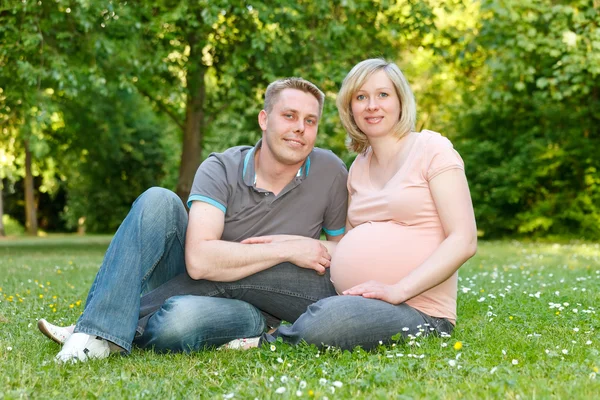在公园里休息的怀孕夫妇 — 图库照片