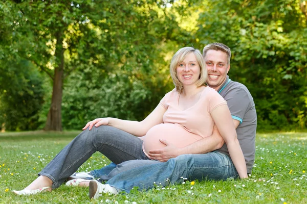 Pareja embarazada descansando en el parque —  Fotos de Stock