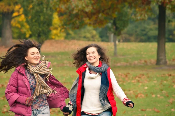 Två vackra flickor att ha roligt i en park — Stockfoto