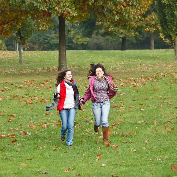 Two pretty girls having fun in autumn park — Zdjęcie stockowe