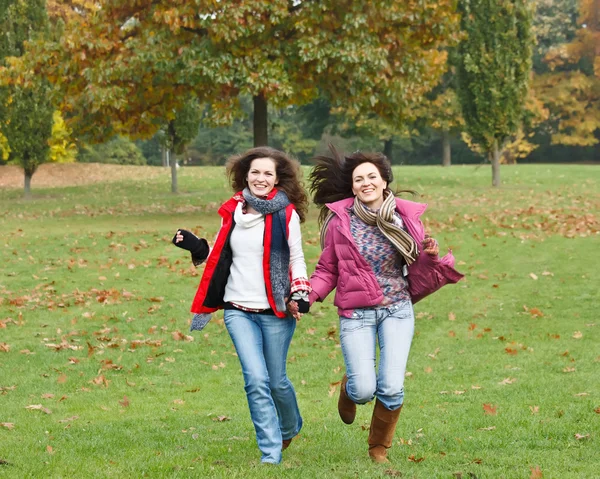 两个漂亮的女孩在秋天公园开心 — 图库照片