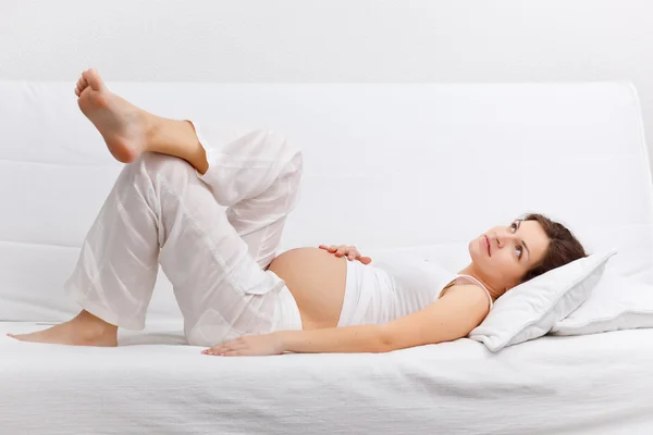 Jonge zwangere vrouw ontspannen op de sofa — Stockfoto
