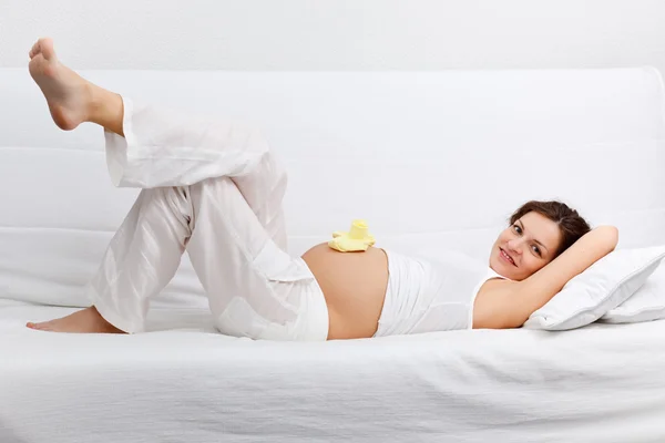 Unga gravid kvinna avkopplande på soffa — Stockfoto