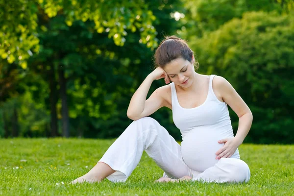 Mooie zwangere vrouw ontspannen in het park — Stockfoto
