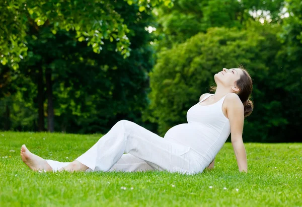 Όμορφη έγκυος γυναίκα χαλαρώνοντας στο πάρκο — Φωτογραφία Αρχείου