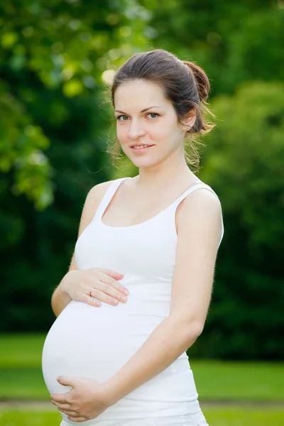 Όμορφη έγκυος γυναίκα χαλαρώνοντας στο πάρκο — Φωτογραφία Αρχείου