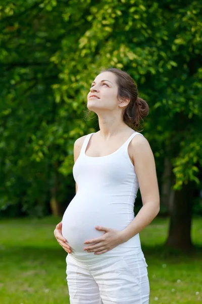Красивая беременная женщина отдыхает в парке — стоковое фото