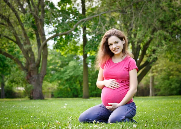 Piękna kobieta w ciąży w parku — Zdjęcie stockowe