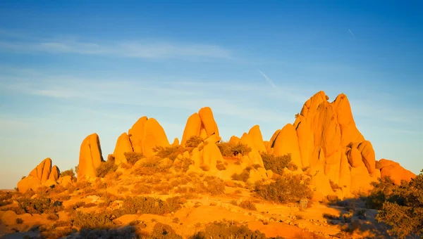日没、モハーベ砂漠、カリフォルニア州に照らされたジョシュア ツリー国立公園内の岩 — ストック写真