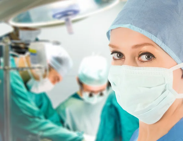 Ženský lékař s chirurgický tým — Stock fotografie