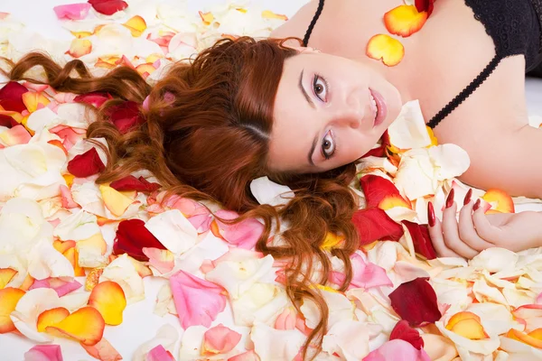 花弁の上に横たわって若い官能的な女性 — ストック写真