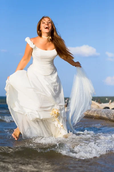 Running laughing bride on the sea — Stock Photo, Image