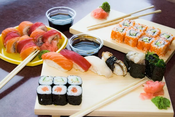 Rollos de sushi con salsa en platos — Foto de Stock