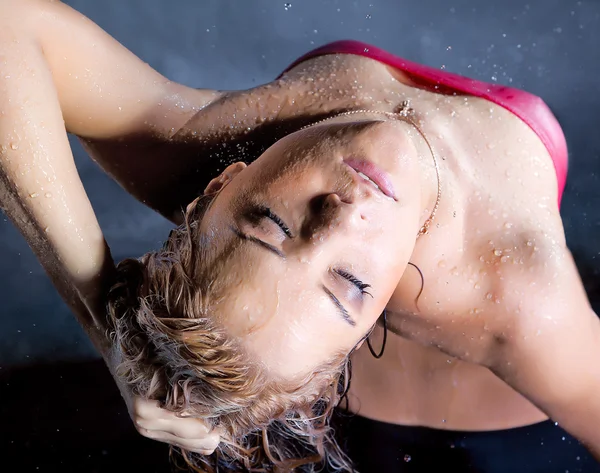 Jonge vrouw genieten in waterdruppels — Stockfoto