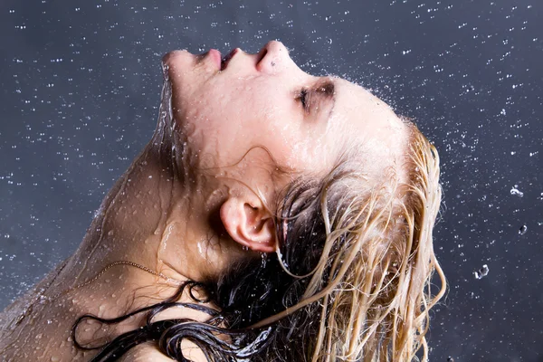 Blonde vrouw met dalende waterdruppeltjes Stockfoto