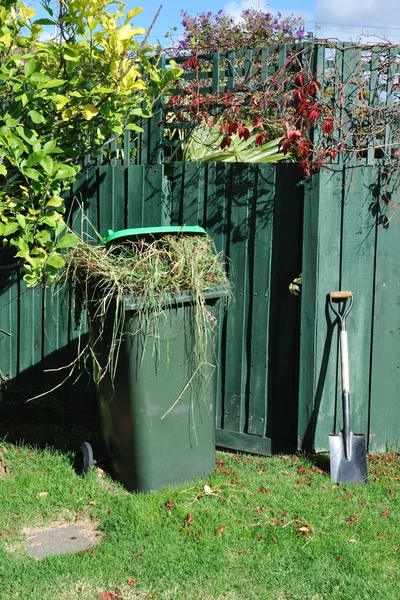 Green bin and spade in backyard — Stock Photo, Image