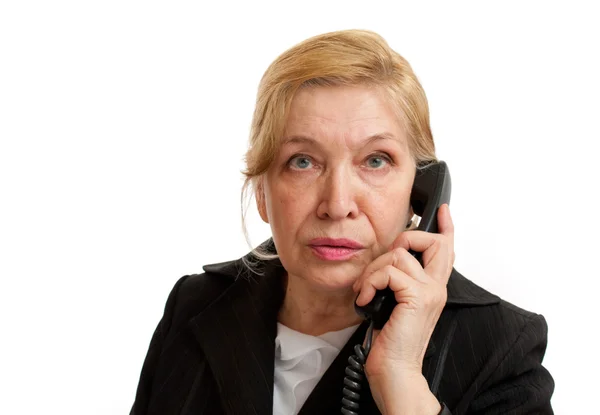 stock image Senior Woman talking on the phone in black suite on white backgr