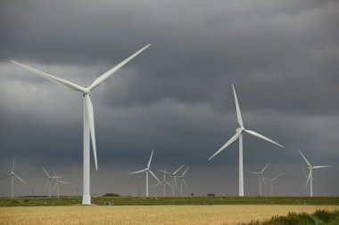 Windmills in front of a cloudy sky clipart