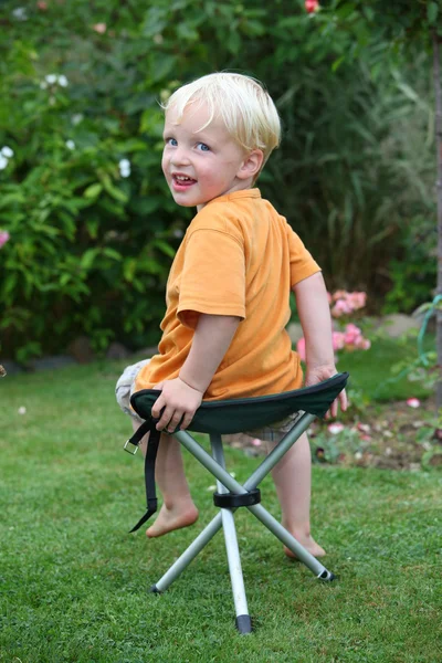 Niño en una silla plegable — Foto de Stock