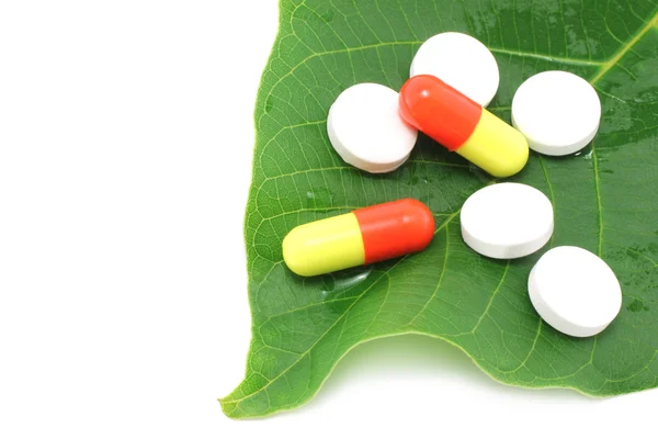 Medikamentenpillen auf dem grünen Blatt — Stockfoto