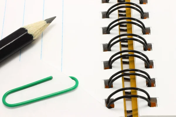Bloc de notas abierto con lápiz y papel con clip — Foto de Stock
