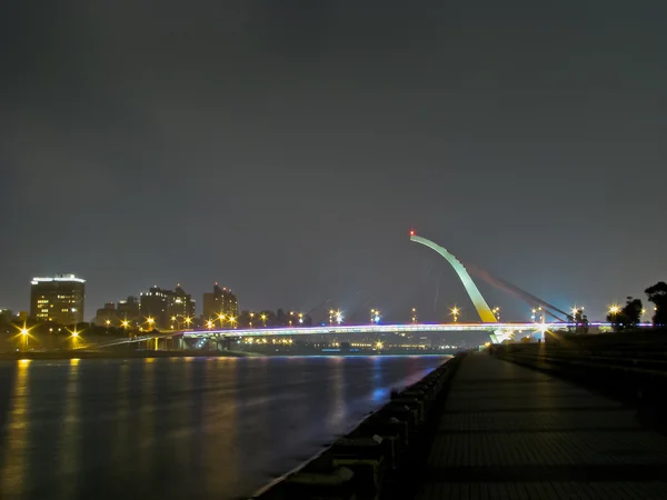 Puente con paisaje urbano brillando por la noche — Foto de Stock