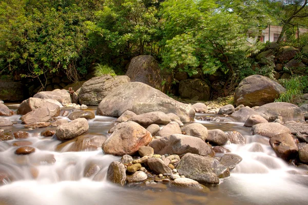 Une cascade sur la roche tombant dans la rivière — Photo