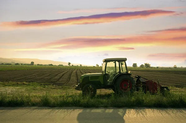 Plowed land and tractor — Stock Photo, Image