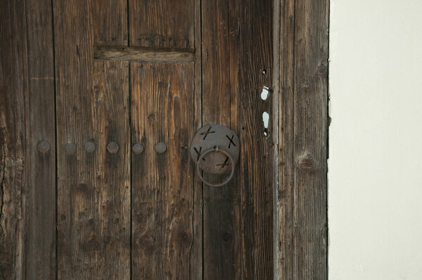 Old brown wooden door. White wall