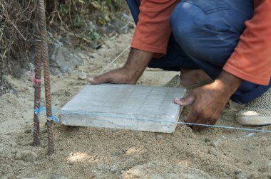 Worker puts sidewalk tiles clipart