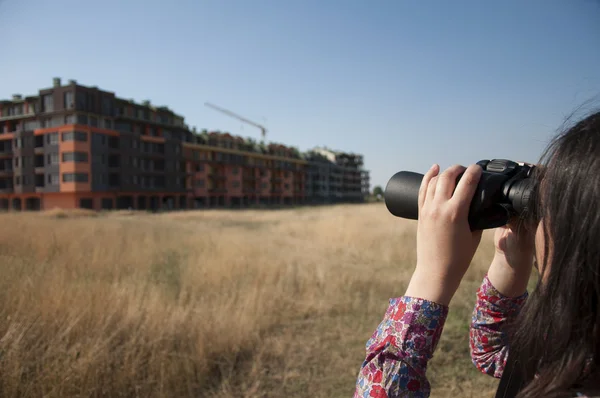 Femme regardant avec des jumelles construction de bâtiments — Photo