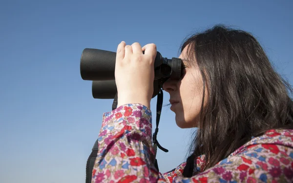 年轻女子使用双筒望远镜 — 图库照片