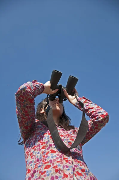 Young woman using binoculars — Stock Photo, Image