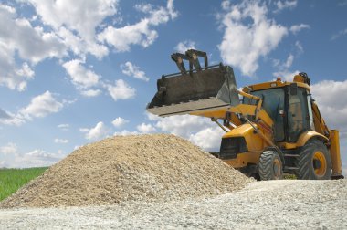 Excavator to a pile of rubble clipart