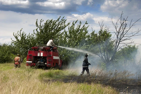 Brandmän släcker en brand — Stockfoto
