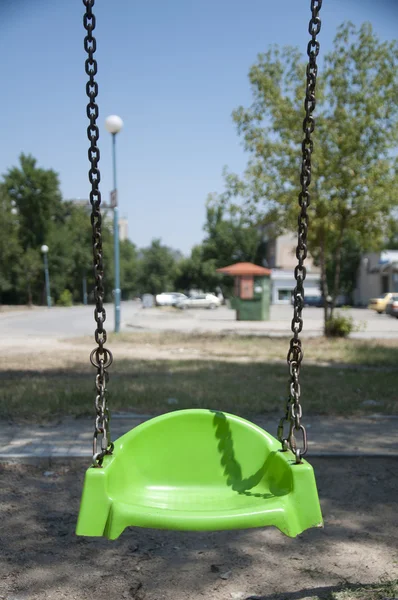 Empty green swing with chain — Stock Photo, Image
