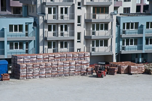 Pallets of bricks in front of new building — Stock Photo, Image