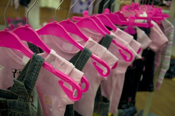 Kläder hänga på galgar i butik — Stockfoto