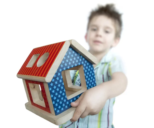 Ahşap renkli ev oyuncak sunan çocuk — Stok fotoğraf
