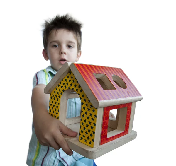 Garçon présentant bois maison colorée jouet — Photo