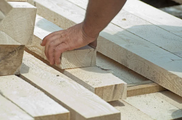 Trabalhador move uma viga de madeira — Fotografia de Stock