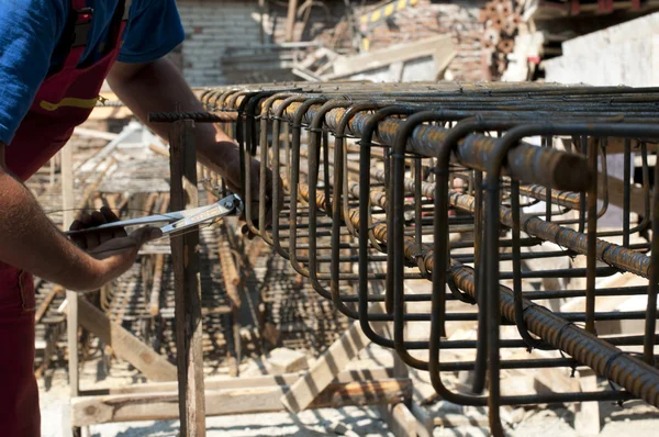 Construction worker ties reinforcing steel — Stock Photo, Image